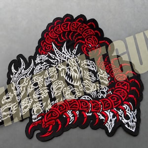 May include: A large embroidered patch featuring a red and black centipede-like creature with a segmented body, intertwined with multiple white skull motifs. The design is set against a black background with a watermark text overlay reading THATPATCHGUY.