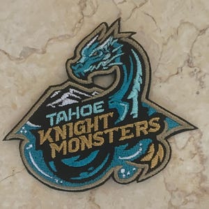 May include: A blue and gold embroidered patch with a dragon, mountains, and the text "Tahoe Knight Monsters".
