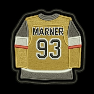 May include: Embroidered patch of a hockey jersey with the name "MARNER" and the number "93" in black on a gold jersey. The jersey has gray sleeves with white and red stripes. The patch has a black border.