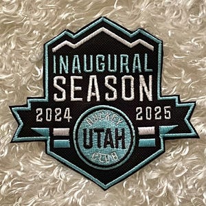 May include: A black and blue embroidered patch with the text "Inaugural Season 2024-2025" and a circle with the text "Hockey Utah Club".