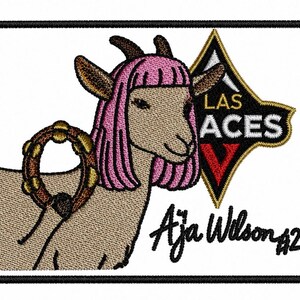 May include: Embroidered patch featuring a goat with pink hair and a tambourine. The patch includes the text "LAS ACES" and "Aja Wilson #22" in black script on a white background, framed by a black border.