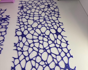 May include: A rectangular, dark blue, 3D-printed sheet featuring an intricate, organic web-like pattern of interconnected lines and irregular open spaces. The surface has a slightly textured, granular finish throughout the entire structure.