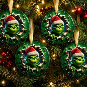May include: Four round green Christmas ornaments featuring a green character wearing a red and white Santa hat, appearing to emerge from a hole in the centre. Each ornament is suspended by a gold ribbon and decorated with small red accents.