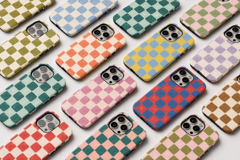 May include: A collection of smartphone cases arranged in a grid, each featuring a two-tone checkerboard pattern. The cases display various color combinations including red, blue, pink, green, yellow, orange, and brown squares on a white base.