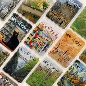 Könnte beinhalten: Eine Sammlung klarer Acryl-Untersetzer mit Vintage-Covern des Magazins The New Yorker. Die Cover zeigen verschiedene Illustrationen, darunter eine schwarze Katze, Herbstszenen und Stadtlandschaften. Jeder Untersetzer hat das Logo des Magazins.