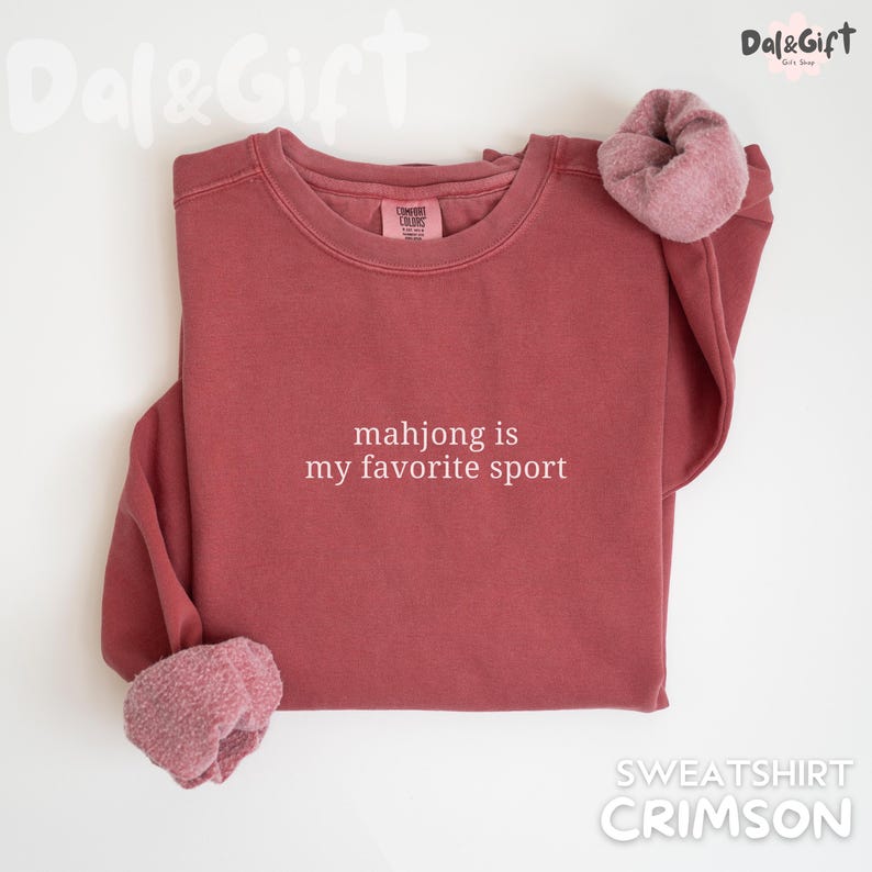 Pu&ograve; includere: Felpa color cremisi con la scritta bianca "mahjong is my favorite sport". La felpa ha un girocollo e una morbida fodera in pile ai polsini. Uno stile comodo e casual.