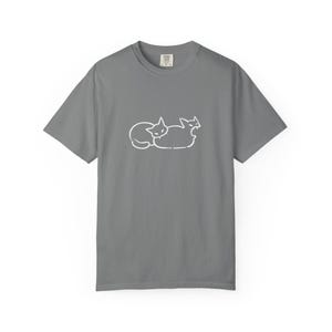 May include: A charcoal gray short-sleeve t-shirt featuring a white line art graphic of two cats on the chest. One cat is curled up while the other is positioned next to it with an open mouth. The shirt has a crew neckline and a standard fit.
