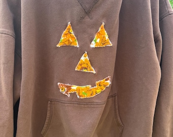 Upgecycelter brauner Hoodie – Kürbisgesicht mit Blumenapplikation (Medium)