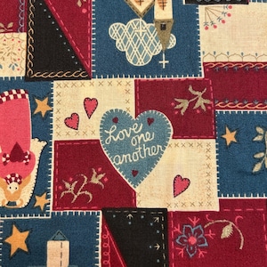 May include: A patchwork fabric with a repeating pattern of squares in red, blue, black, and cream. Each square features embroidered designs of hearts, houses, stars, and floral motifs. The phrase "Love one another" is stitched on a heart.