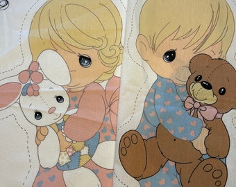 Puede incluir: Dos paneles de tela con ilustraciones de niños en pijama. Uno de los niños sostiene un conejito, el otro un osito de peluche. Los pijamas de los niños son de color azul claro y rosa con estampados de corazones. Las ilustraciones están delineadas con una línea discontinua.
