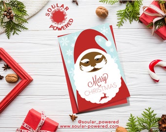 May include: A red and white Christmas card with a cartoon illustration of Santa Claus with a brown beard and a white beard. The text "Merry Christmas" is written in white on a red background. The card has a blue background with white snowflakes.