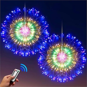 Può includere: Due luci decorative a forma di stella filante illuminate con telecomando. Le luci presentano LED blu, verdi, gialli e rosa, creando un effetto festoso. Il telecomando è tenuto in mano.