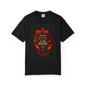 May include: Black t-shirt with a graphic design. The design features the text "THE DEVIL HAS NO KEYS TO HIS HOUSE" in red and yellow, with a fiery background and the text "REV 1:18".