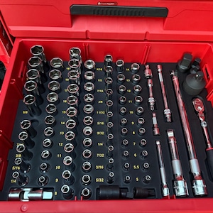Könnte beinhalten: Eine rote Werkzeugschublade gefüllt mit einer Vielzahl von Chrom-Steckschlüsseln, Verlängerungen und Ratschen. Die Werkzeuge sind in einer schwarzen Schaumstoffeinlage organisiert, mit Größenangaben in Zoll. Eine Snap-on-Ratsche ist sichtbar.