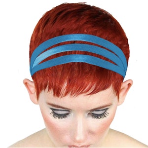 Könnte beinhalten: Ein blaues Stirnband mit drei Stofflagen. Das Stirnband wird von einer Person mit kurzen, roten Haaren getragen.