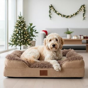May include: A light brown dog bed with a plush, faux fur sleeping surface. The bed has a rectangular shape with a raised edge and a small, brown leatherette tag. A golden doodle dog is lying on the bed.