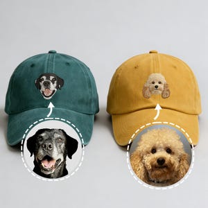Pode incluir: Dois bonés de beisebol, um verde-azulado e outro amarelo mostarda, cada um bordado com o rosto de um cão. O boné verde-azulado apresenta um cão preto e branco, enquanto o boné amarelo tem um poodle. Ambos os bonés têm uma aba curva.