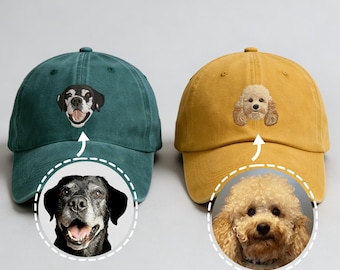 Puede incluir: Dos gorras de béisbol, una verde azulado y otra amarillo mostaza, cada una bordada con la cara de un perro. La gorra verde azulado presenta un perro blanco y negro, mientras que la gorra amarilla tiene un caniche. Ambas gorras tienen una visera curva.