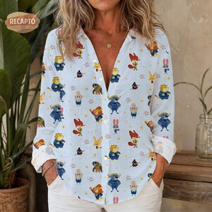 May include: Light blue button-down shirt with a whimsical pattern of cartoon animals, including foxes, lions, and rabbits. The long-sleeved shirt features rolled-up cuffs and a relaxed fit, perfect for casual wear.
