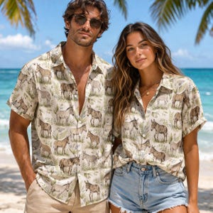 May include: Two short-sleeved button-down shirts with a repeating donkey pattern in shades of brown and green on a cream background. The shirts are worn by a man and a woman on a beach, suggesting a vacation or resort theme.