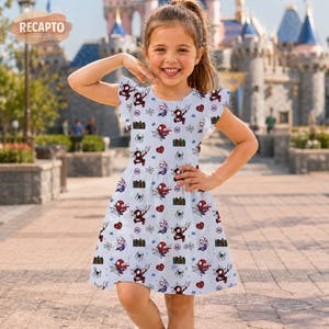 May include: A light blue dress featuring a repeating pattern of Spider-Man, spiderwebs, and hearts. The dress has short, ruffled sleeves and a flared skirt. The background shows a castle and a young girl smiling.