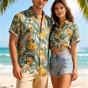 Może przedstawiać: Pasujące koszule z krótkim rękawem z nadrukiem tropikalnych liści i Pluto psa. Koszule są zielone, białe i żółte. Tło przedstawia scenę na plaży z palmami i błękitną wodą.