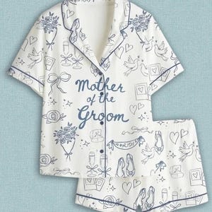 May include: A white pajama set with short sleeves and shorts, featuring dark blue piping and a repeating line-art pattern of wedding motifs including doves, bouquets, rings, and champagne flutes. The shirt reads Mother of the Groom.