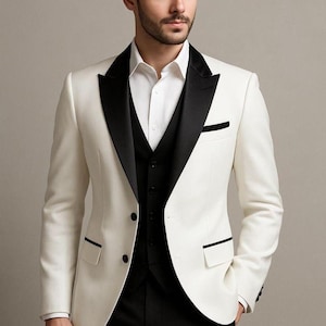 May include: A formal white suit with black lapels, a black vest, and black pants. The suit has a classic two-button closure and black trim on the pockets. The text "GOODCHOIC EBySameer" is visible at the top.