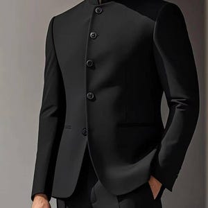 Puede incluir: Un traje negro con cuello mao y cierre de botones. El traje tiene un corte entallado y se lleva con pantalones negros. El texto "GOODCHOICEBySameer" es visible en la parte superior de la imagen.