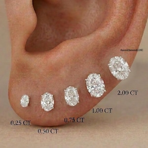 Op de afbeelding: Een oor met vijf ovale diamantstud-oorbellen in verschillende maten, variërend van 0,25 CT tot 2,00 CT. De diamanten zijn gezet in een lichtgekleurd metaal, tegen een neutrale achtergrond. De tekst "AuroraDiamondLUXE" is zichtbaar.