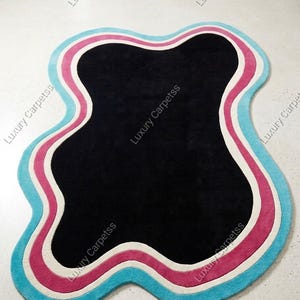 Handgemaakt wollen getuft vloerkleed, onregelmatige abstracte vorm, zwart centrum kleurrijke rand woonkamertapijt