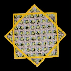 May include: A star-shaped fabric item with a yellow border, featuring a repeating pattern of neon yellow smiley faces with X-shaped eyes and the text Rave Kreationz printed in black on a light, iridescent, and swirling tie-dye background.