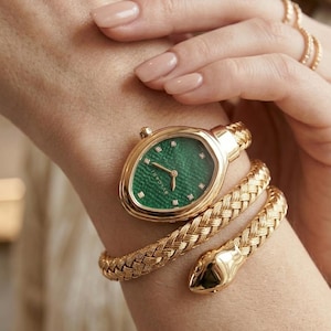 May include: A gold watch with a textured green dial featuring small diamond hour markers. The watch has a unique snake-inspired design with a flexible, braided gold band that wraps around the wrist, ending in a polished gold snake head.