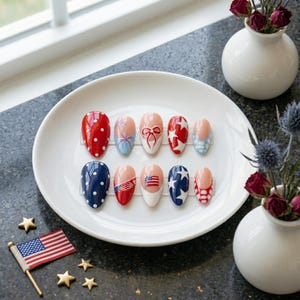 May include: A white ceramic mug with a black handle and the text "But First, Coffee" in a bold, black font. The mug is set against a blurred background, suggesting a cozy setting.