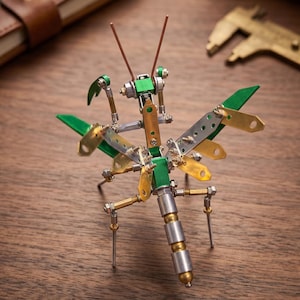 May include: A detailed metal dragonfly sculpture with green, silver, and gold accents. The insect has articulated wings and legs, and is constructed from various metal components. The sculpture is displayed on a wooden surface.