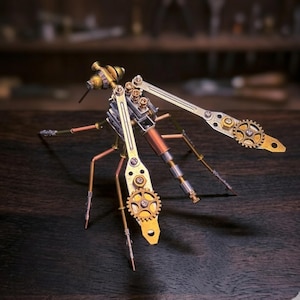 Puede incluir: Una detallada escultura de libélula de estilo steampunk. El insecto está construido con componentes de latón, cobre y metal plateado, incluyendo engranajes, varillas y remaches. Las alas son articuladas y el cuerpo presenta una combinación de formas cilíndricas y angulares. La escultura se exhibe sobre una superficie de madera oscura.