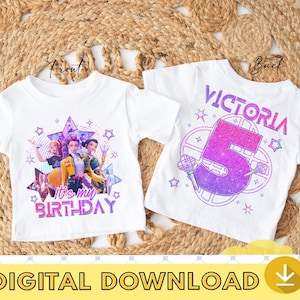 Puede incluir: Dos camisetas blancas con diseños de cumpleaños. Una camiseta dice "It's my birthday" con un gráfico de tres chicas. La otra camiseta dice "Victoria 5" con un gráfico de micrófono. Las camisetas están sobre una estera tejida.