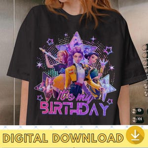 May include: Black t-shirt featuring a graphic of three animated figures in front of a star-shaped background with the text "It's my BIRTHDAY" in purple glitter. The design includes stars and a digital download icon.