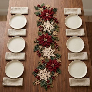 May include: A table runner featuring a crocheted design of red poinsettia flowers, cream-colored snowflakes, green leaves, and small red berries. The runner is centered on a wooden table with six white plates and six beige linen napkins.