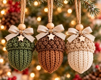 Puede incluir: Tres adornos de bellotas de ganchillo en verde, marrón y crema. Cada bellota presenta una tapa texturizada, una cuenta de madera lisa, un lazo de tela beige y un pequeño dije de estrella de madera. Cuelgan de lazos de yute natural.