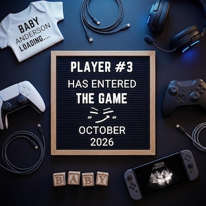 Op de afbeelding: Een zwangerschapsaankondiging met gaming-thema. Een witte babyromper met de tekst "BABY ANDERSON LOADING....". Een letterbord leest "PLAYER #3 HAS ENTERED THE GAME" met "OKTOBER 2026". Gamecontrollers, een koptelefoon en een echo van de baby zijn ook aanwezig.