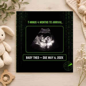 K&ouml;nnte beinhalten: Ein rechteckiges Schild mit schwarzem Hintergrund, gr&uuml;nem Bin&auml;rcode, einem zentralen Ultraschallbild und dem Text T-MINUS 4 MONTHS TO ARRIVAL sowie BABY THEO - DUE MAY 6, 202X. Eine gr&uuml;ne Radargrafik befindet sich in der unteren rechten Ecke.
