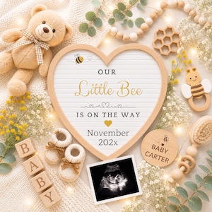 May include: A heart-shaped announcement board with the text "Our Little Bee Is On The Way" and "November 202x". The image includes a teddy bear, baby shoes, ultrasound image, and wooden blocks spelling "BABY".