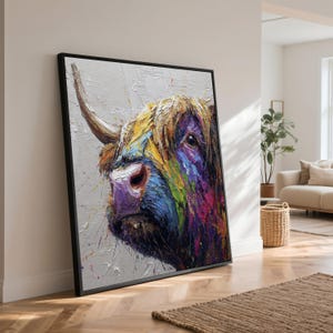 May include: A framed canvas print depicting a Highland cow. The artwork showcases a close-up of the cow's head, with vivid brushstrokes in blue, purple, yellow, and green. The cow's fur is textured, and the background is a neutral grey.