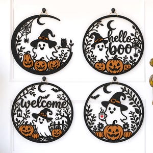 May include: Four circular black wall hangings featuring white ghosts wearing orange-accented hats, orange pumpkins, and foliage. One sign says "hello boo" and another says "welcome". The designs include spiders, webs, bats, and an owl.