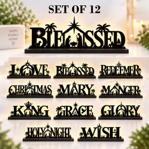 Könnte beinhalten: Ein Set aus 12 lasergeschnittenen schwarzen Holzschildern mit hinterleuchteten Krippenszenen, die in die Wörter BLESSED, LOVE, REDEEMER, CHRISTMAS, MARY, MANGER, KING, GRACE, GLORY, HOLY NIGHT und WISH integriert sind, jeweils auf einem Sockel.
