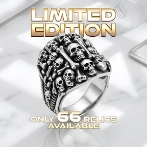 May include: A silver-colored ring featuring a detailed design of skulls and bones. The ring has the words "LIMITED EDITION" and "ONLY 66 RELICS AVAILABLE" in gold lettering.