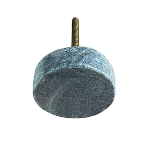 Pode incluir: Um puxador de arm&aacute;rio cil&iacute;ndrico cinza com um parafuso de lat&atilde;o roscado. O puxador &eacute; feito de um material manchado semelhante a pedra. O hardware &eacute; projetado para m&oacute;veis e decora&ccedil;&atilde;o de casa.