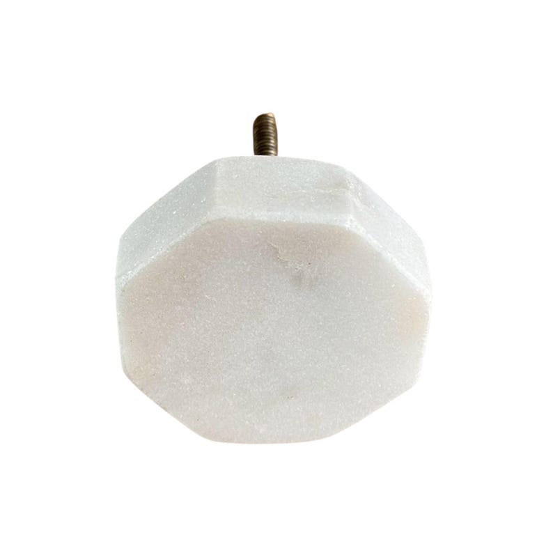 Pode incluir: Um puxador de arm&aacute;rio de m&aacute;rmore branco com formato octogonal. O puxador possui um parafuso de lat&atilde;o para instala&ccedil;&atilde;o. A ferragem &eacute; projetada para uso em gavetas, arm&aacute;rios ou outros m&oacute;veis.