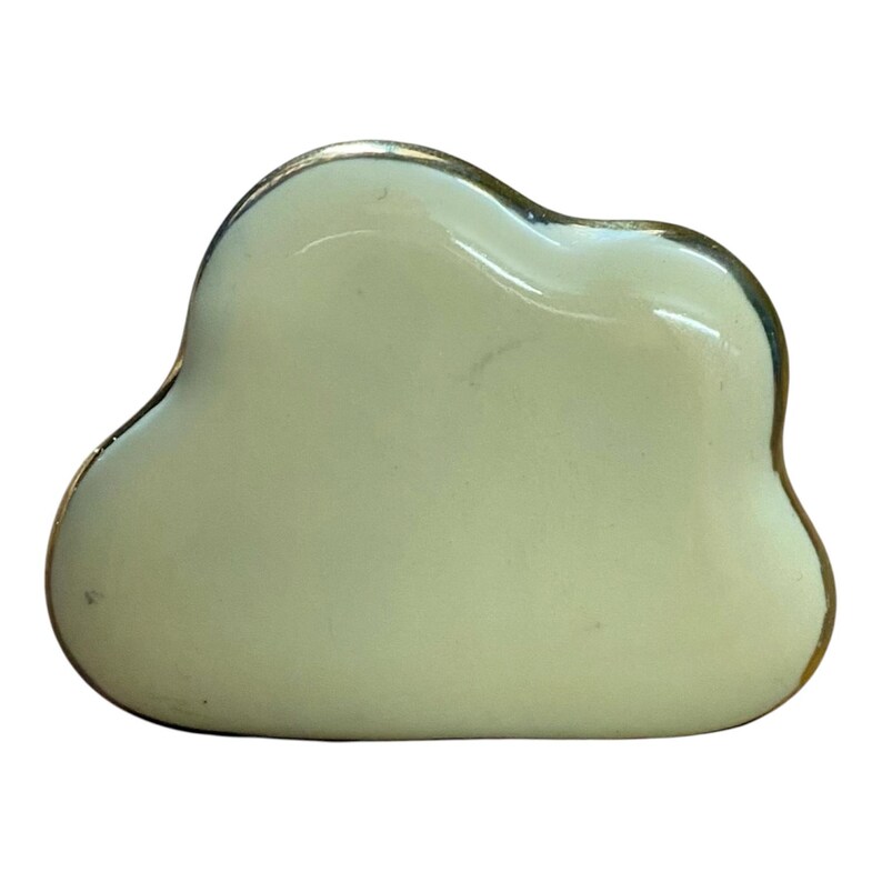 May include: A cloud-shaped decorative object with a pale yellow finish and a gold-coloured trim. The object has a smooth, glossy surface and a rounded, irregular shape. The design is simple and elegant.